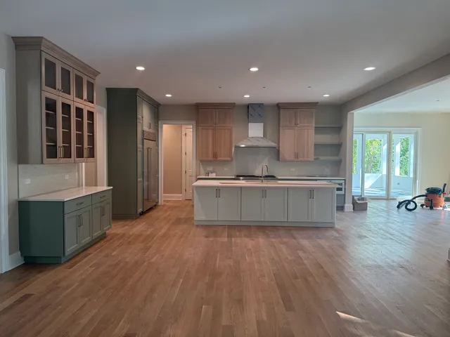 a large kitchen with stainless steel appliances granite countertop a stove a sink and a refrigerator