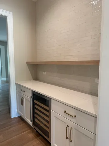 a kitchen with white cabinets and a wooden floor