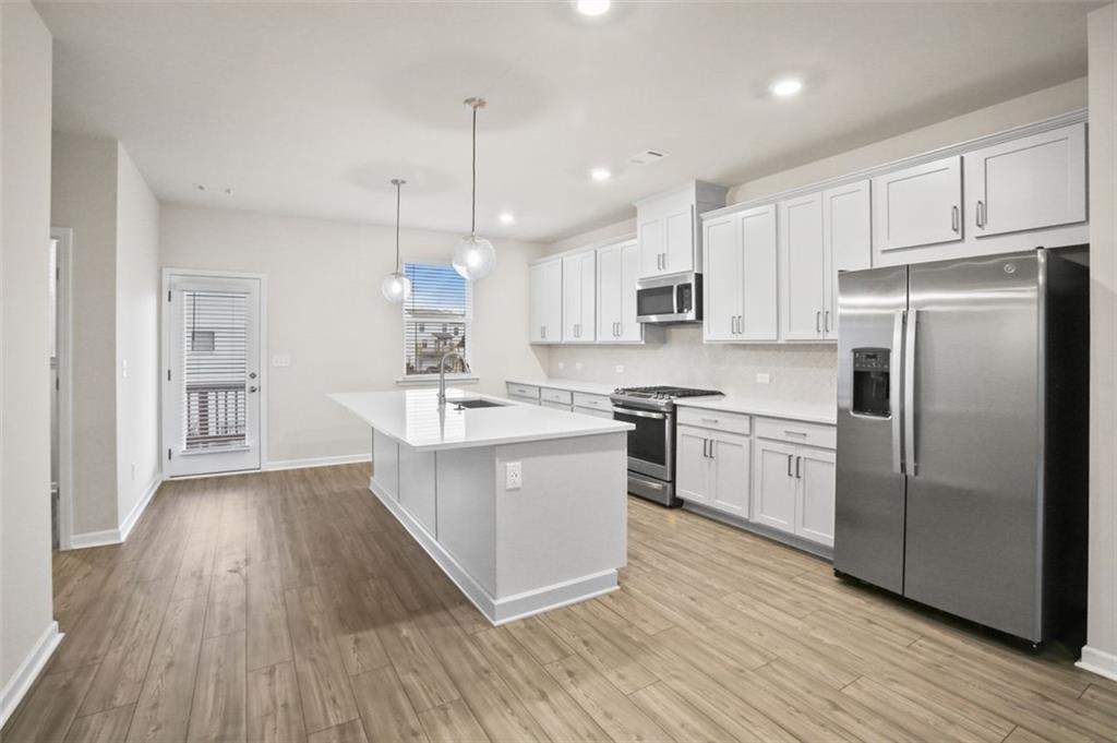 26 Peeples Drive Lawrenceville, GA 30046 - Photo 5 of 24 a kitchen with a refrigerator a sink and wooden floor
