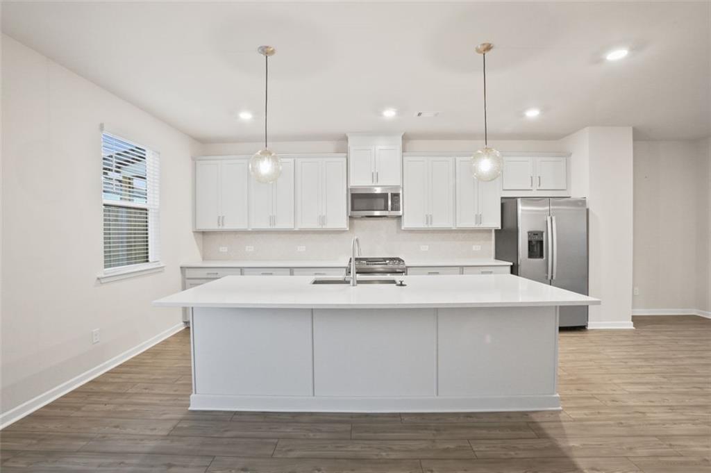 26 Peeples Drive Lawrenceville, GA 30046 - Photo 6 of 24 a kitchen with kitchen island a sink stainless steel appliances and cabinets