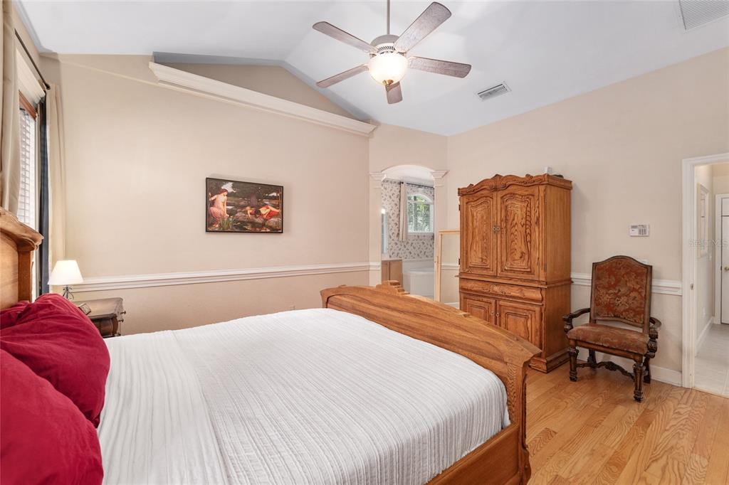 9513 Southwest 33 Lane Gainesville, FL 32608 - Photo 35 of 68 a bedroom with a bed a chair and a chandelier