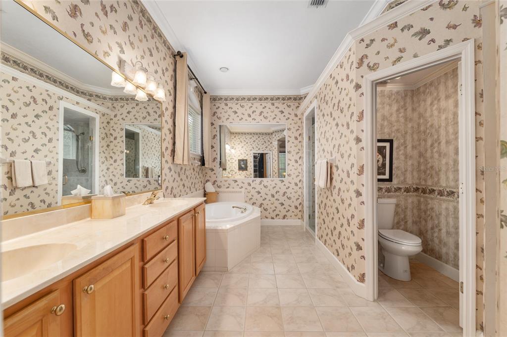 9513 Southwest 33 Lane Gainesville, FL 32608 - Photo 37 of 68 a spacious bathroom with a double vanity sink toilet mirror and shower