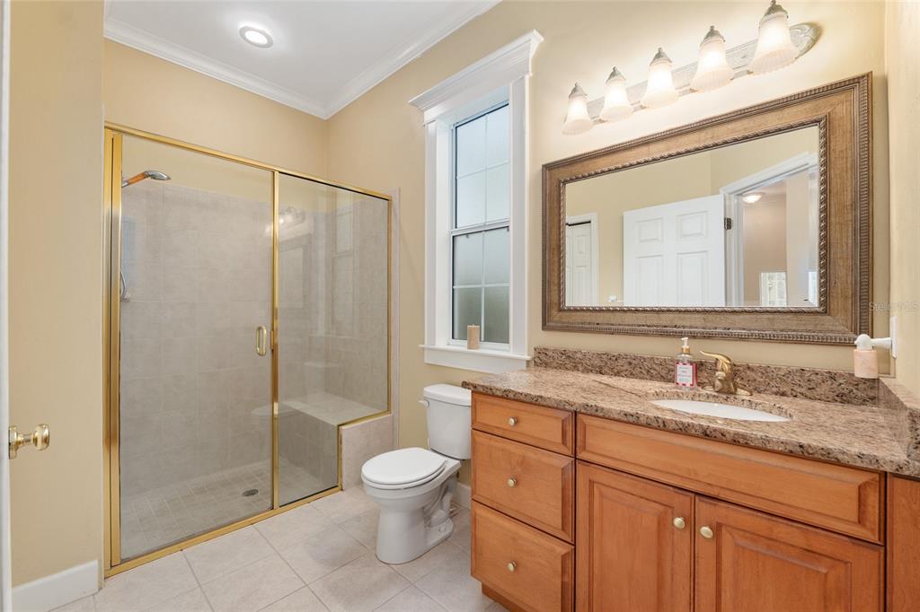 9513 Southwest 33 Lane Gainesville, FL 32608 - Photo 50 of 68 a bathroom with a granite countertop sink a mirror and a shower