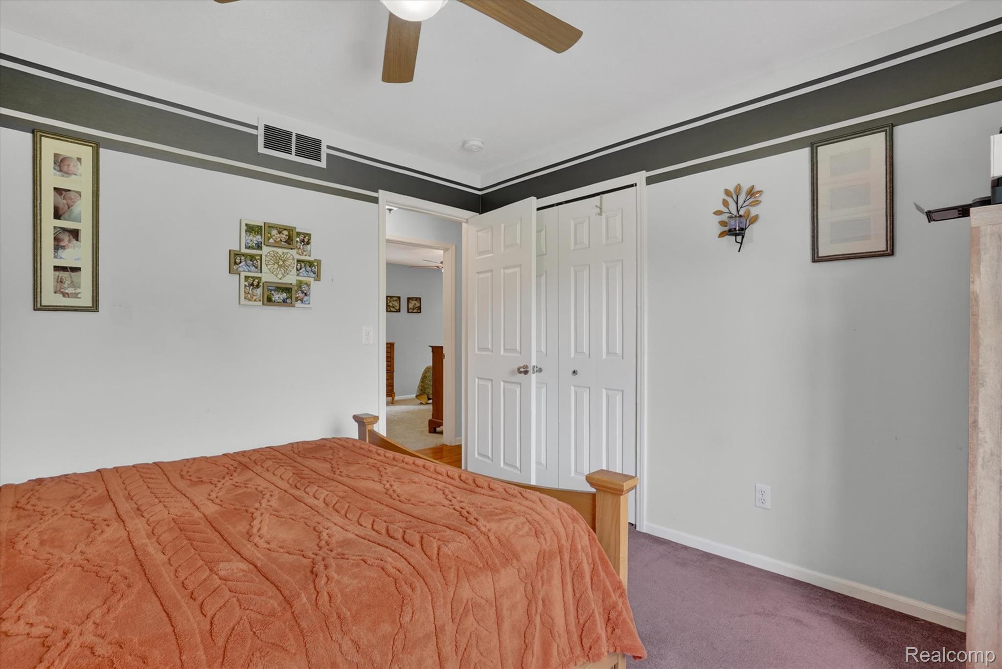 9565 Crofoot Road Fowlerville, MI 48836 - Photo 17 of 63 Carpeted room featuring a ceiling fan with integrated lighting, dual-door closet, and white trim molding