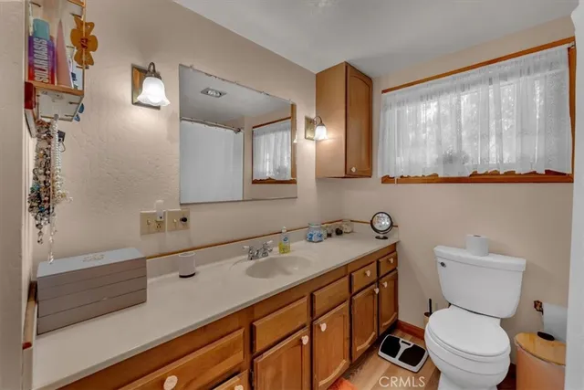a bathroom with a toilet sink double vanity and mirror