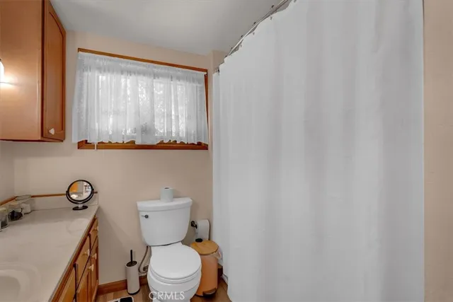 a bathroom with a toilet a sink and a mirror