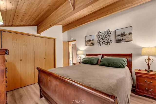 a bedroom with a large bed and wooden floor