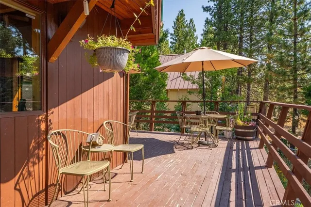 a roof deck with table and chairs under an umbrella
