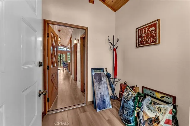 a view of a hallway with wooden floor and closet