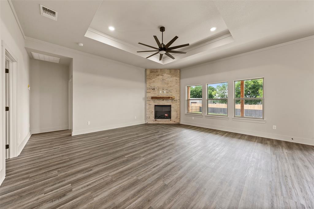 138 Dana Pt Road Lorena, TX 76655 - Photo 5 of 24 Spacious interior showcasing wood-finish flooring, a tray ceiling with recessed lighting, and a modern ceiling fan