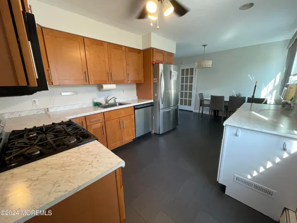 a kitchen with stainless steel appliances granite countertop a sink stove and refrigerator