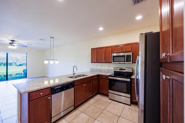 a kitchen with stainless steel appliances granite countertop a sink a stove and a refrigerator