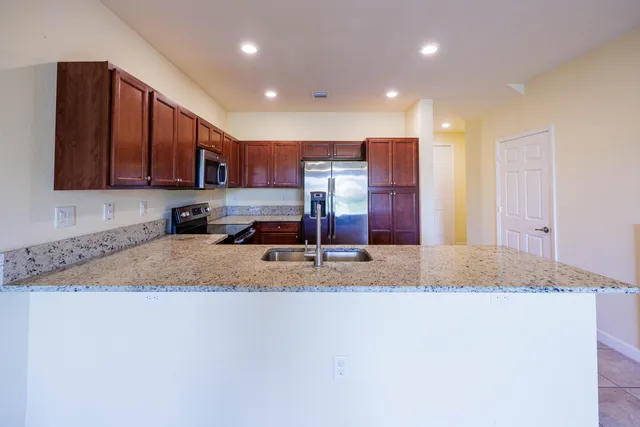 a view of kitchen with stainless steel appliances granite countertop sink stove and cabinets