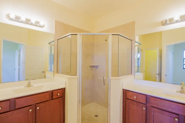 a bathroom with a double vanity sink mirror and shower
