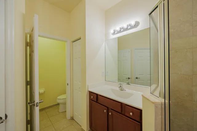 a bathroom with a double vanity sink a toilet and a mirror