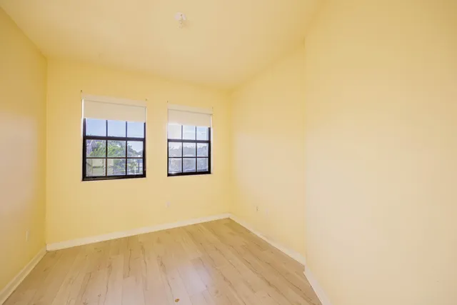 a view of a small space with wooden floor and a window