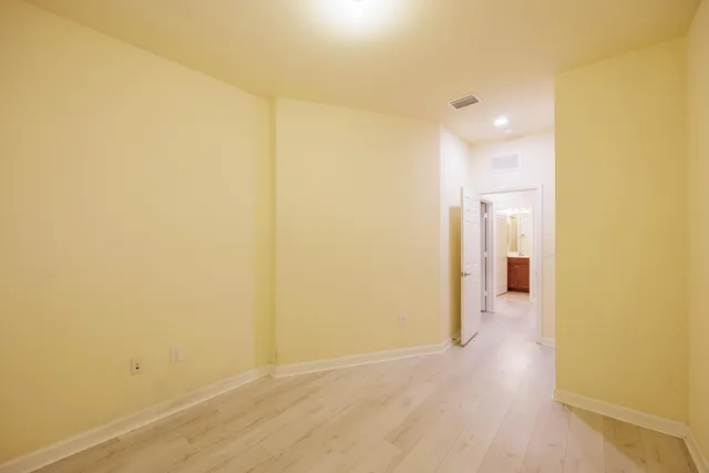 a view of a room with wooden floor and a bathroom