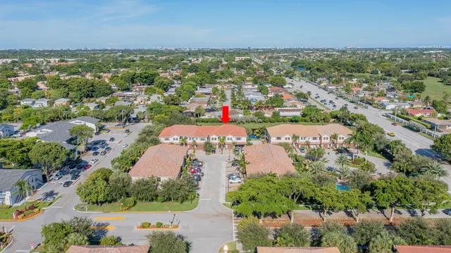 an aerial view of residential houses with outdoor space and trees