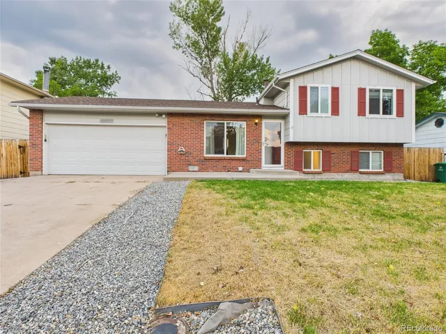 a front view of a house with a garden and yard