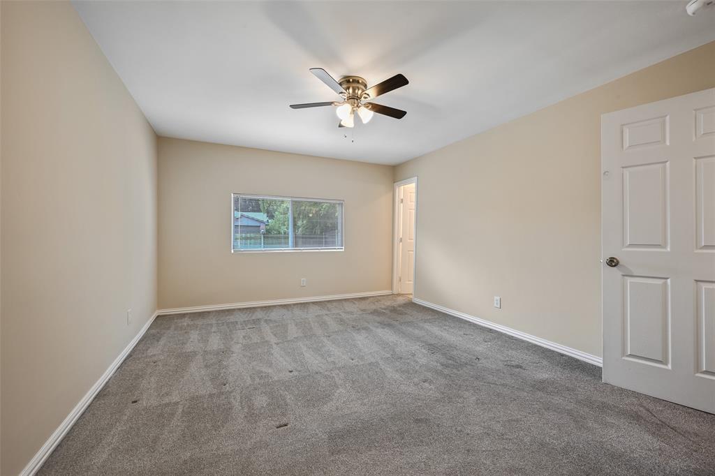 7318 Emory Oak Lane Dallas, TX 75249 - Photo 14 of 28 Spacious room featuring neutral-toned walls, grey carpet flooring, a ceiling fan with integrated lighting, and a single window offering exterior views