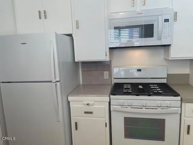 a stove top oven sitting inside of a kitchen