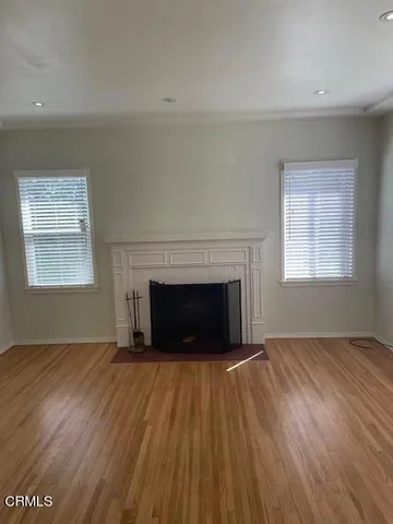 a view of empty room with wooden floor and fireplace