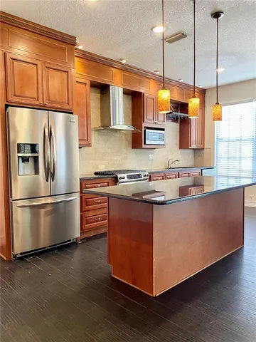 a kitchen with stainless steel appliances granite countertop a refrigerator a stove a sink and a microwave