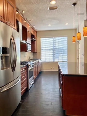 a kitchen with stainless steel appliances granite countertop a refrigerator a sink and a stove