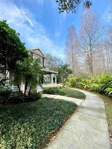 a view of a house with a yard and large tree