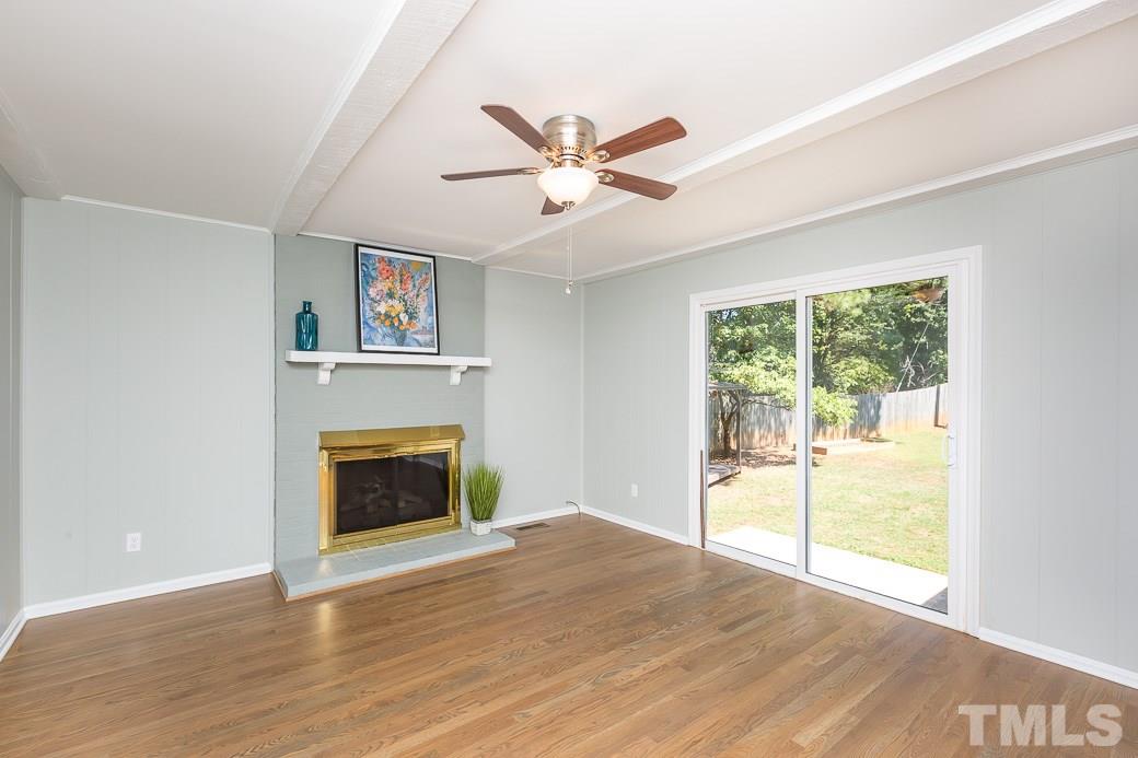 400 Old Farm Road Raleigh, NC 27606 - Photo 15 of 23 Enjoy this spacious family room with welcoming fireplace and beamed ceiling. New site-laid hardwood floors. Walls and fireplace freshly painted, new fan and new energy efficient sliding glass door allowing lots of natural light.