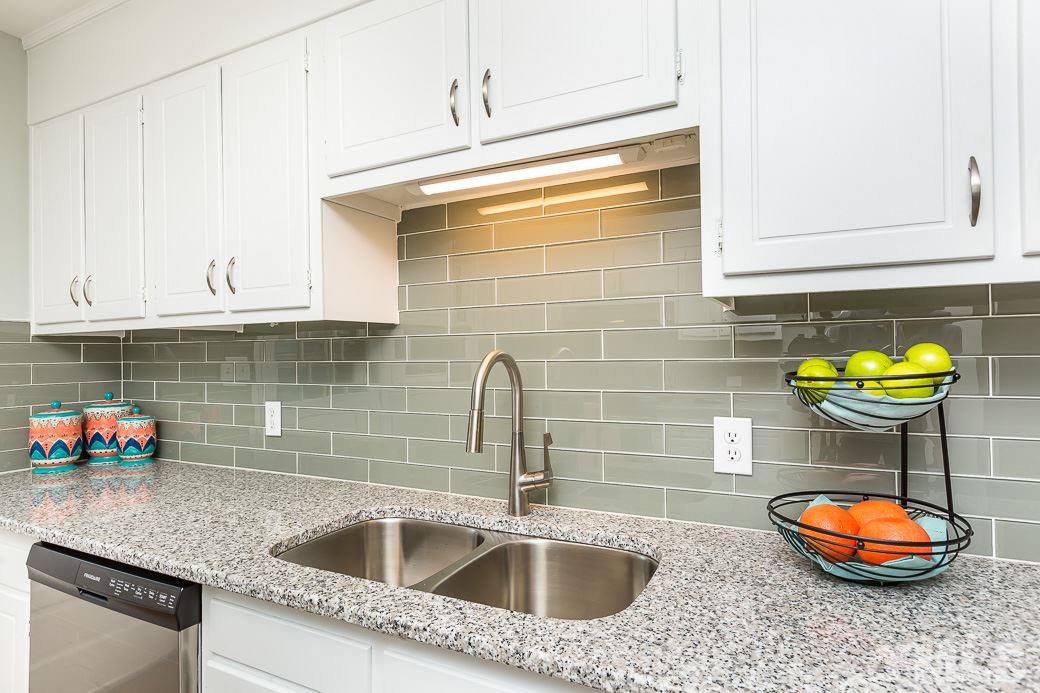 400 Old Farm Road Raleigh, NC 27606 - Photo 10 of 23 Bright kitchen offering freshly painted cabinets & new granite counter tops w/ lots of task space & storage.New glass subway tile back splash, double-bowl stainless sink w/Hansgrohe faucet, new lighting fixtures, new stainless appliances. New site-laid HW