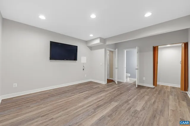 a view of a livingroom with wooden floor and a flat screen tv