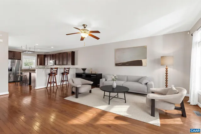 a living room with furniture and a view of kitchen