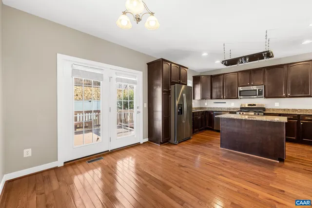 a kitchen with stainless steel appliances granite countertop a refrigerator stove top oven and sink