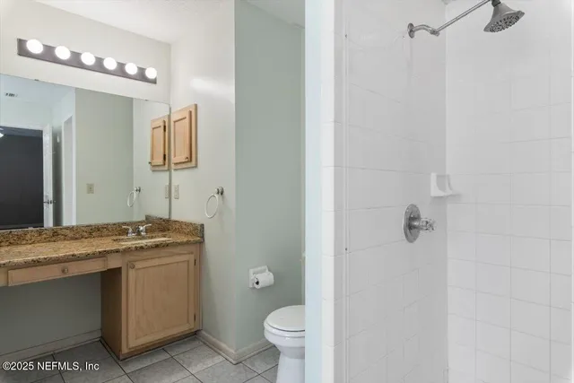 a bathroom with a granite countertop sink a toilet and a mirror