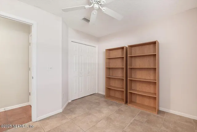 a view of an empty room with a ceiling fan