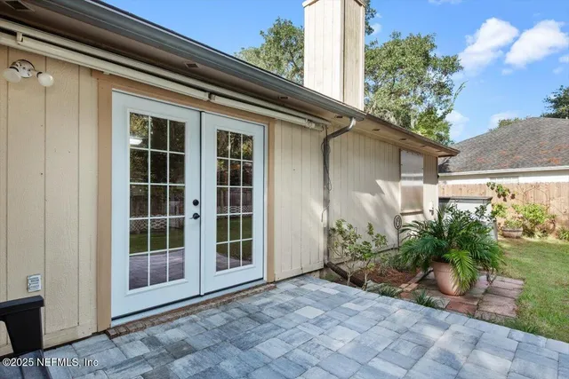 a view of house with potted plants in front of door