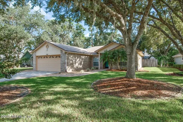 a view of a house with backyard and a tree