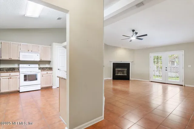 a view of a kitchen with stainless steel appliances a refrigerator and a stove top oven