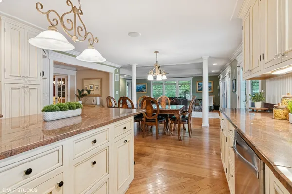 a view of a dining room and livingroom with furniture wooden floor a chandelier