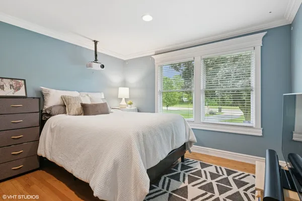 a bed sitting in a spacious bedroom next to a window