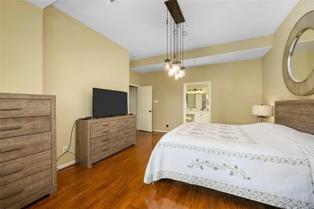 a spacious bedroom with a bed and a chandelier