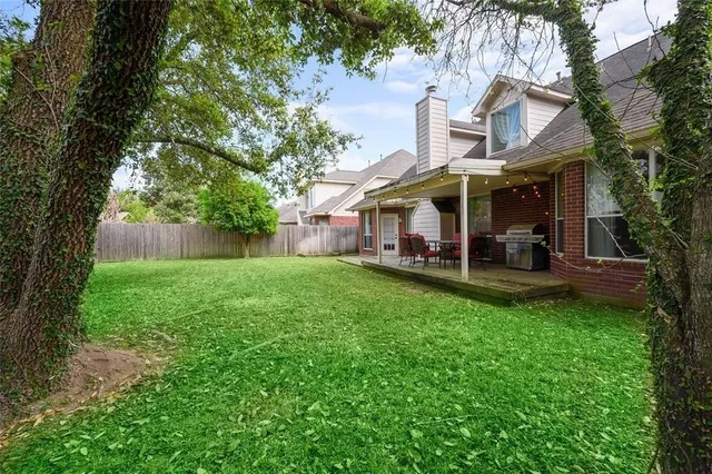 a view of a house with backyard and a tree