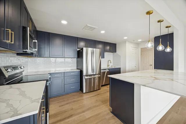 a kitchen with a refrigerator a sink and wooden cabinets
