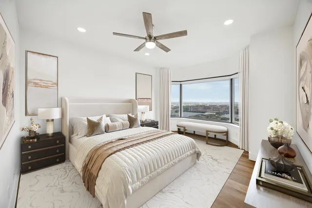 a bedroom with a bed and a large window