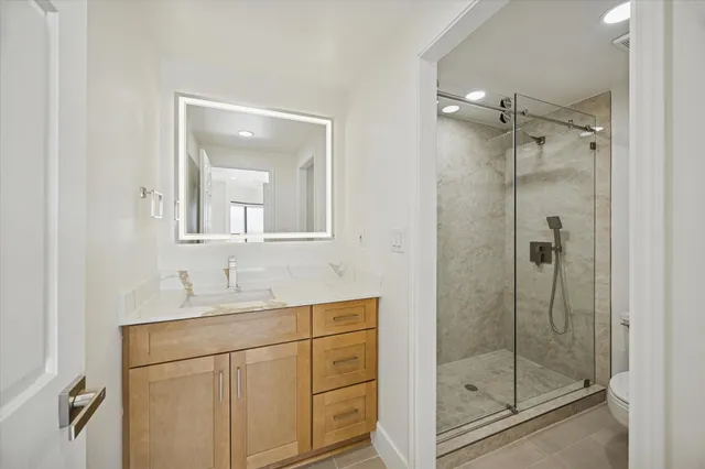 a bathroom with a shower sink and mirror