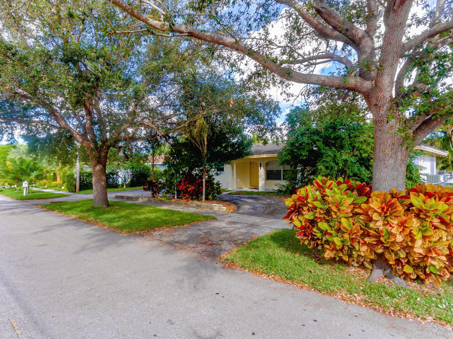 2411 Northeast 46th Street Lighthouse Point, FL 33064 - Photo 11 of 12 a front view of a house with a yard and a garage