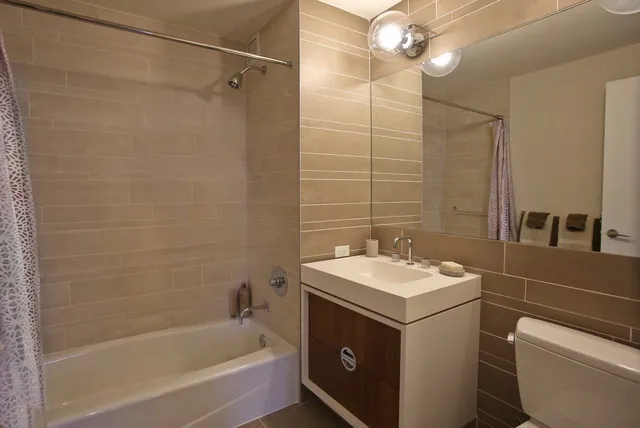a bathroom with a sink toilet vanity and shower