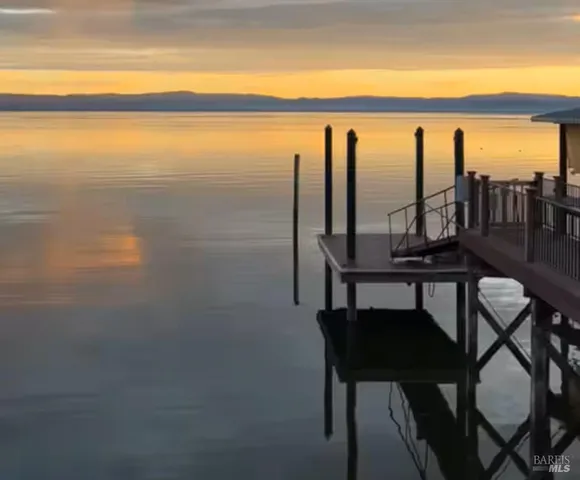a view of a lake from a balcony with furniture