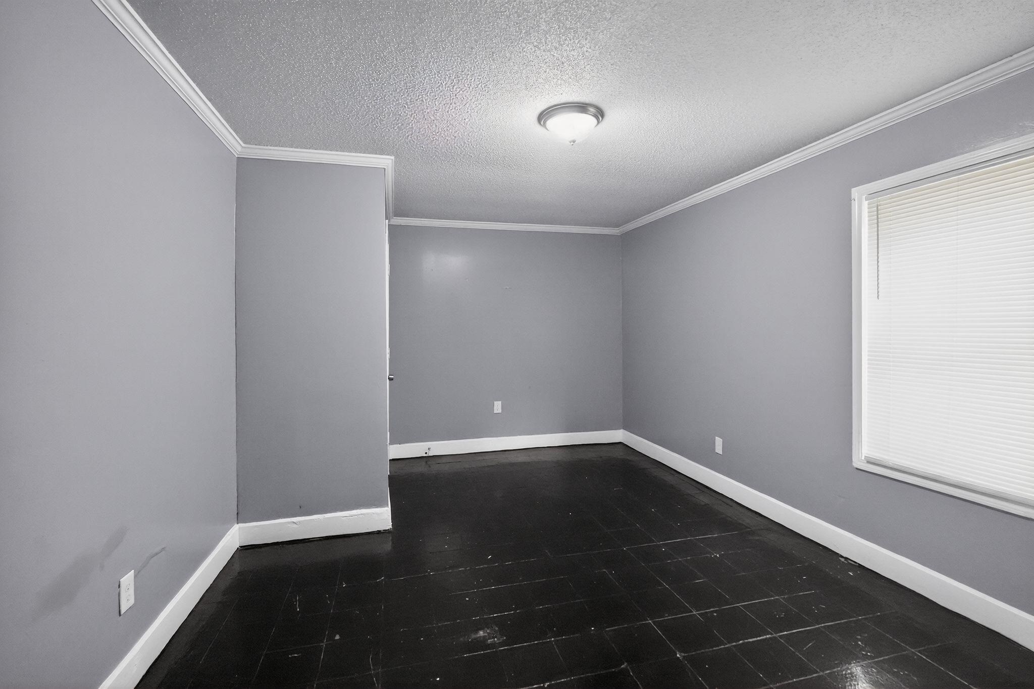 4199 Auburn Road Memphis, TN 38116 - Photo 16 of 32 Spacious interior room featuring dark wood-finish flooring, light gray wall paint, white crown molding, and white baseboards